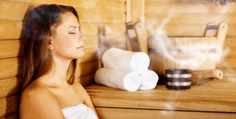 Junge Frau sitzt in einer Sauna