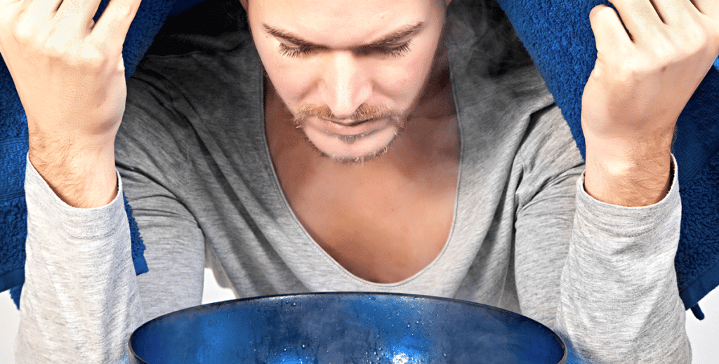 Junge Mann inhaliert über eine Schüssel