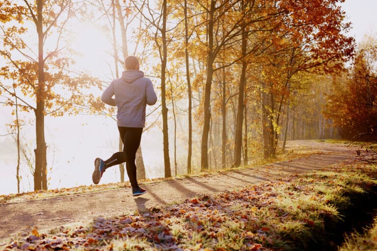 Junger Mann Joggt bei Sonnenuntergang im Wald