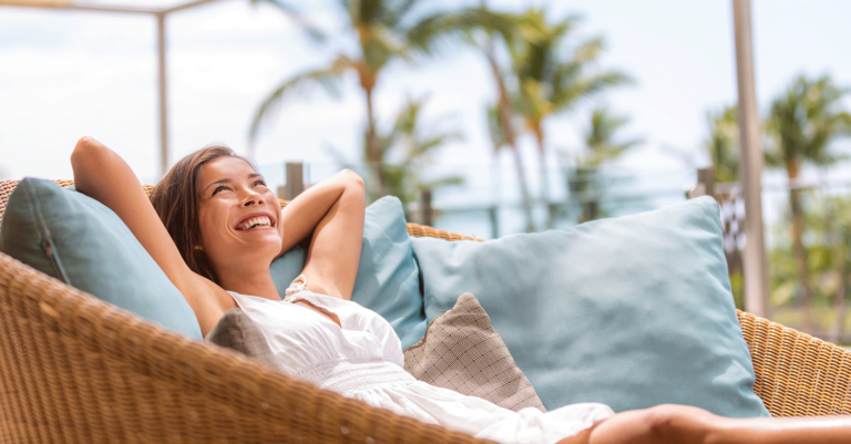 Junge Frau liegt genießt due Sonne auf einer Terrasse