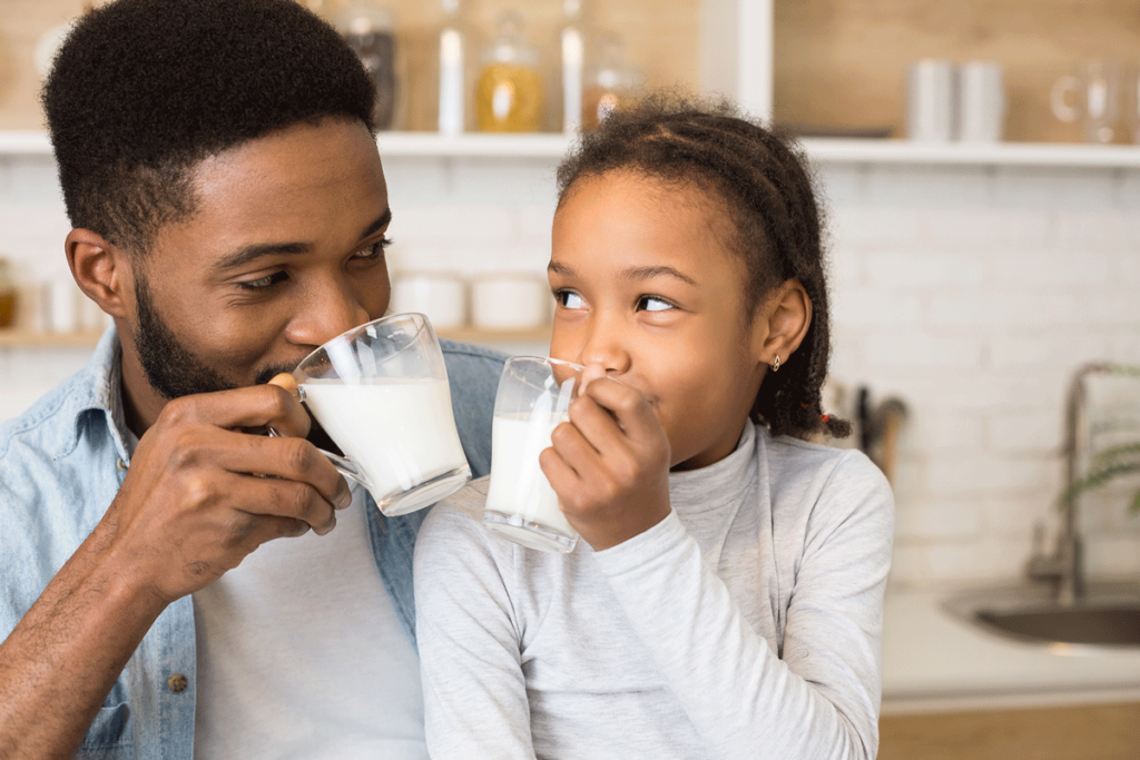 Vater und Tochter trinken ein Glas Milch