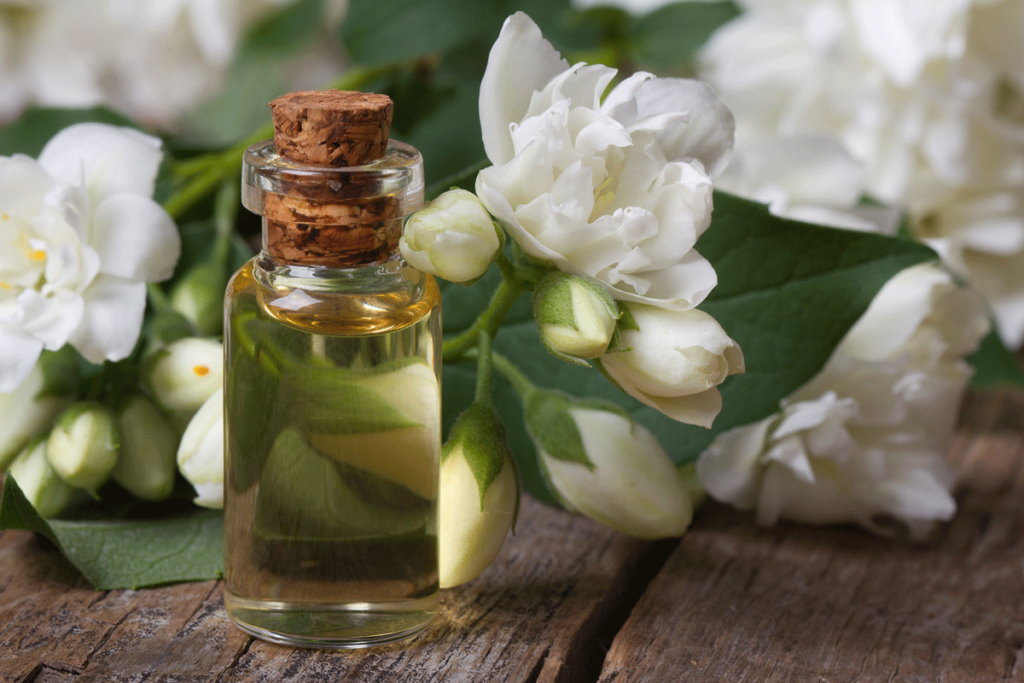 Jasminöl mit Jasminblüten auf einem Tisch