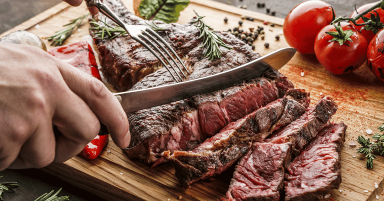 Saftiges Stück Fleisch wird auf einem Brett geschnitten