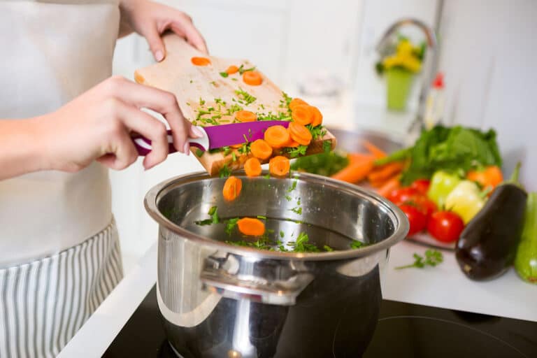 Vitamin A haltige Karotten werden in eine Suppe getan.
