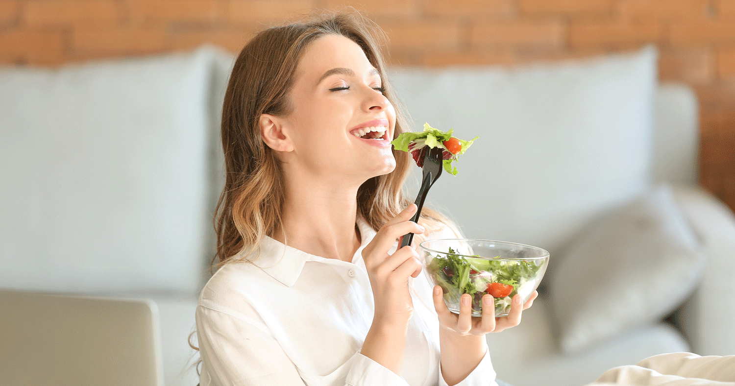 Junge Frau isst einen frischen Salat