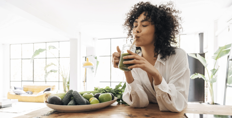 Junge Frau genießt einen Gemüsesmoothie