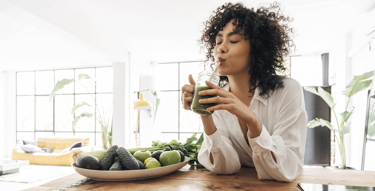 Junge Frau genießt einen Gemüsesmoothie